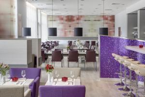 a dining room with tables and purple chairs at IntercityHotel Ingolstadt in Ingolstadt
