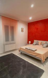 - une chambre dotée d'un lit avec un mur rouge dans l'établissement La Casa del Giglio, à Albenga