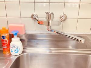 a sink with a faucet and a bottle of soap at stay's ジローズ浄心 601号 名古屋 民泊 駅近 in Nagoya +27 photos