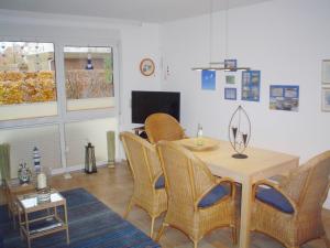 een woonkamer met een tafel en stoelen en een televisie bij Fewo Strandrevier in Zingst