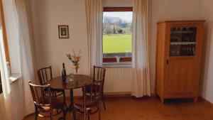 a dining room with a table and chairs and a window at Aich21 in Peißenberg