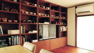 a book shelf with a window and a table and chairs at Akizuki Niwa (Garden) House in Asakura