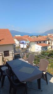 a table and chairs on a balcony with buildings at Belane Apartments in Tivat