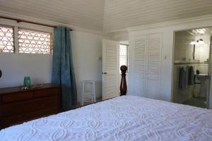 a bedroom with a bed and a dresser and a window at Zenbreak Freshwater Beachfront 6 in Saint Michael