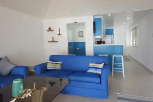 a living room with a blue couch and a table at Zenbreak Freshwater Beachfront 6 in Saint Michael