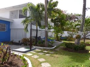 a house with palm trees in the yard at Zenbreak Freshwater Beachfront 6 in Saint Michael