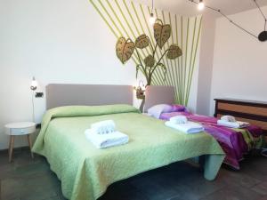 sypialnia z 2 łóżkami i ręcznikami w obiekcie Casa Marilla w Weronie