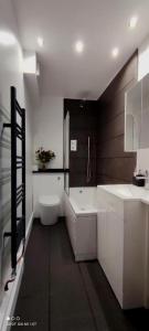 a bathroom with two sinks and a toilet in it at Birds Nest Residency in London