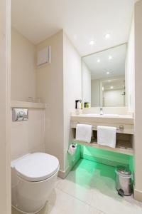 a bathroom with a white toilet and a sink at Holiday Inn Winchester, an IHG Hotel in Winchester