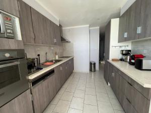 a kitchen with wooden cabinets and a tile floor at La Goélette ou Souléou front de mer 3étoiles appartement 2 chambres in Toulon