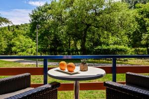 einen Tisch auf einem Balkon mit zwei Orangen darauf in der Unterkunft Campsite & Holiday Resort Medveja in Medveja