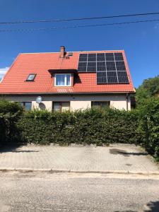 a house with a red roof with solar panels on it at Apartament Lux in Gołdap