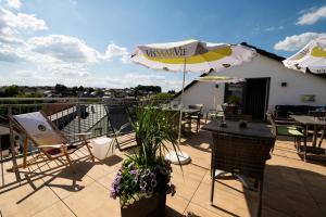 梅特拉赫Vis Saar Vie - Ferienwohnungen an der Saarschleife的带桌椅和遮阳伞的露台