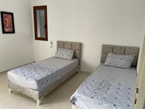 2 Betten nebeneinander in einem Zimmer in der Unterkunft Zahra 1 in Houmt Souk