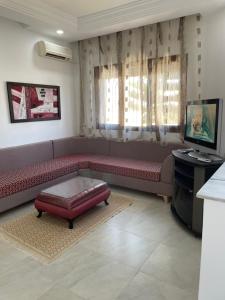 salon z czerwoną kanapą i telewizorem w obiekcie Zahra 1 w mieście Houmt Souk