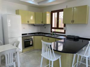 a kitchen with yellow cabinets and a table and chairs at Zahra 1 in Houmt Souk