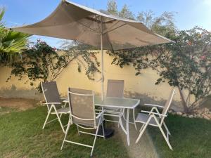 a table and chairs under an umbrella in the grass at Zahra 1 in Houmt Souk