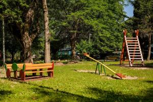 einen Park mit Spielplatz mit Rutsche und Bank in der Unterkunft Campsite & Holiday Resort Medveja in Medveja