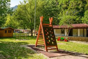 a playground with a ladder and a swing set at Campsite & Holiday Resort Medveja in Medveja