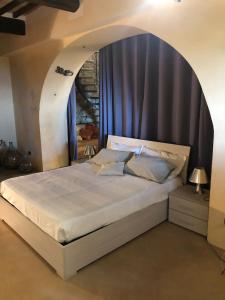 a bedroom with a large bed with an arch overhead at Casa Chiassarello in Roccastrada