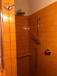 y baño con ducha de azulejos de color naranja. en Casa Chiassarello, en Roccastrada