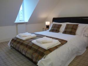 a bedroom with a bed with towels on it at Glenmorangie Highland Club Scotland in Fort Augustus