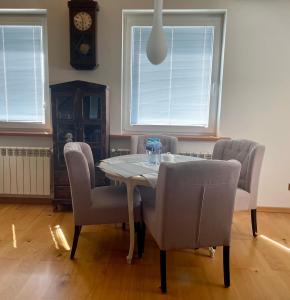 uma sala de jantar com mesa e cadeiras e um relógio em VIP apartment in Mogilany close to Kraków Air con WLAN Highspeed em Mogilany