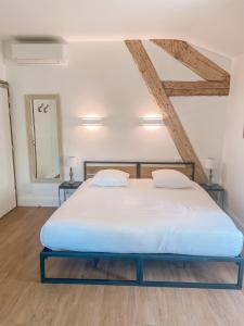 a bedroom with a large white bed with two tables at Hotel Savel in Ruoms