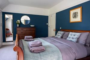 ein Schlafzimmer mit einem großen Bett mit blauen Wänden in der Unterkunft Anoush in Everton