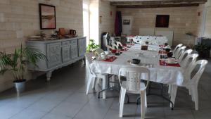 una gran mesa blanca y sillas en una habitación en Chambre d'Hôtes - La Rigaudière, en Le Theil-de-Bretagne