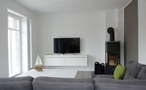 un soggiorno con divano e TV a schermo piatto di Haus Veronika links a Wyk auf Föhr
