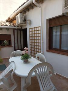 una mesa blanca y sillas en un patio en La Sal Home Toledo, en Toledo