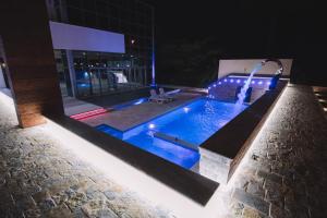 a swimming pool at night with blue lights at Hotel Liana in Ulcinj