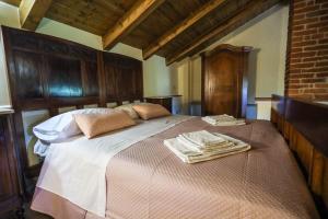 una camera da letto con un grande letto con asciugamani di Dimora dei Greci 1 a Paestum