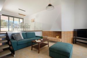 a living room with a blue couch and a table at Serenity Villa in Kórinthos