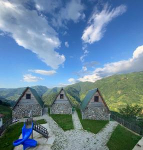 a group of cottages with mountains in the background at Elabay Dağ Evleri in Çamlıhemşin