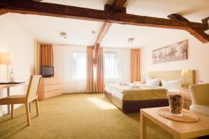 1 dormitorio con cama, mesa y sofá en Altes Forsthaus Braunlage en Braunlage