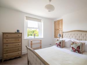 a bedroom with a bed and a window at Kimkeri in Bourton on the Water