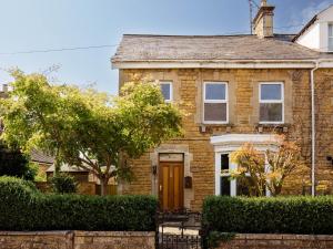 a brick house with a brown door at Kimkeri in Bourton on the Water