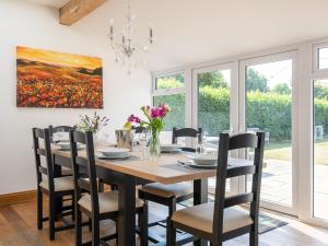 a dining room table with chairs and a painting on the wall at Kimkeri in Bourton on the Water