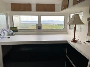 a kitchen with a desk with a lamp and a window at Wilsons Prom Views - Prom View Shack 