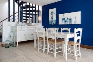 a dining room with a white table and chairs at Ajaches 23 in Puerto Calero