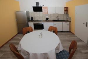 a kitchen with a white table and chairs in a room at Ferienwohnung-Monteurzimmer Rolandseck in Wahnwegen
