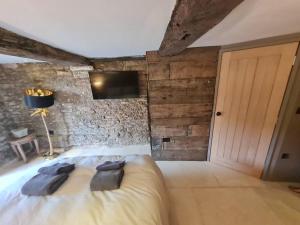 a bedroom with a bed and a tv on a wall at The Undercoft luxury private studio at The Old Church House central Frome in Frome