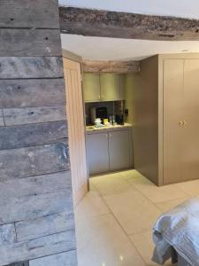 a kitchen with a wooden wall in a room at The Undercoft luxury private studio at The Old Church House central Frome in Frome