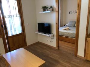 ein kleines Zimmer mit einem Schlafzimmer mit einem Bett und einem Spiegel in der Unterkunft Mandilar 202 Panticosa pie de pistas in Panticosa