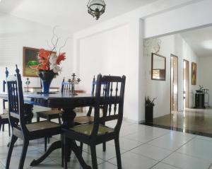 tavolo da pranzo con sedie e vaso di fiori di Casa de férias a cinco minutos da praia a Conde