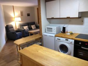 eine Küche mit einer Waschmaschine und ein Wohnzimmer in der Unterkunft Mandilar 202 Panticosa pie de pistas in Panticosa