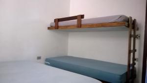 2 Etagenbetten in einem Zimmer mit einem blauen Bett in der Unterkunft Cond Apartamentos Chalés San Marino in Ubatuba