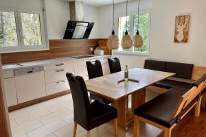 a kitchen with a wooden table and black chairs at Haus Heimetli - CharmingStay in Flumserberg